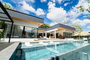 A modern house with a swimming pool, large windows, and a covered outdoor area. - Luxury Casa McCash: Private spa with a hot tub, sauna, pool, and cold plunge pool (Tamarindo)