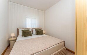 A bedroom with a bed, two bedside tables, and a window with curtains. - Nice apartment in Vir with WiFi (Vir)