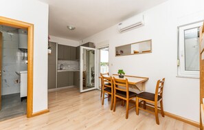 Ein kompakter Wohnbereich mit Essplatz, Küche und einem kleinen Balkon.