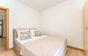 A bedroom with a bed, pillows, and a wooden floor. - Nice apartment in Vir with house sea view (Vir)