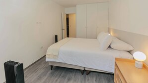 Un dormitorio con cama, mesita de noche y armario.