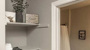 Ein Badezimmer mit Handtuchhalter, einer Zimmerpflanze und einem Schild an der Wand.