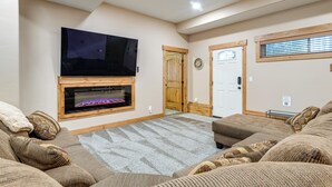 Ein Wohnzimmer mit Kamin, Fernseher und Deckenventilator.