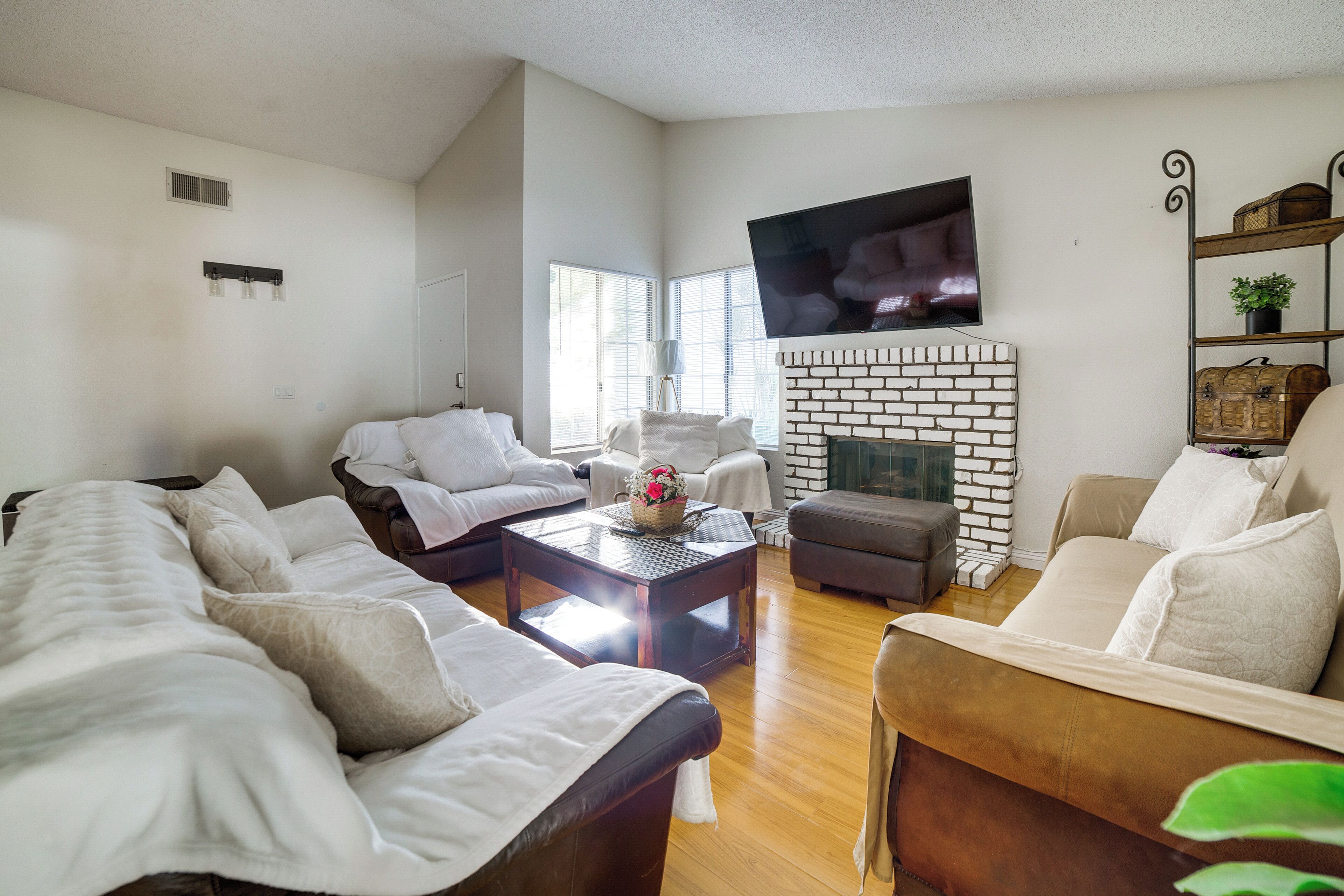 A living room with a fireplace, a television mounted on the wall, and a comfortable seating area with sofas and a coffee table.