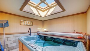 Un jacuzzi con panel de control, un perchero y un cartel que dice 'RELAX' en la pared.