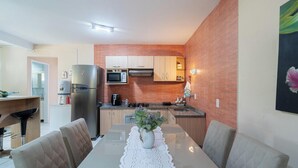 A modern kitchen with a brick backsplash, stainless steel appliances, and wooden cabinets. - Apt w/ 2 Bedrooms and Barbecue Grill Fdc0005 (Florianópolis)
