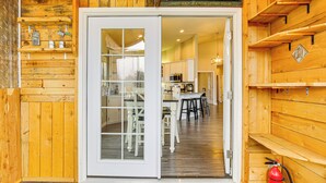 Une cabane en bois comprenant un coin repas, une cuisine et une enseigne au-dessus de la porte.