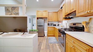 Une cuisine moderne avec des meubles en bois, des appareils en acier inoxydable et un îlot central.
