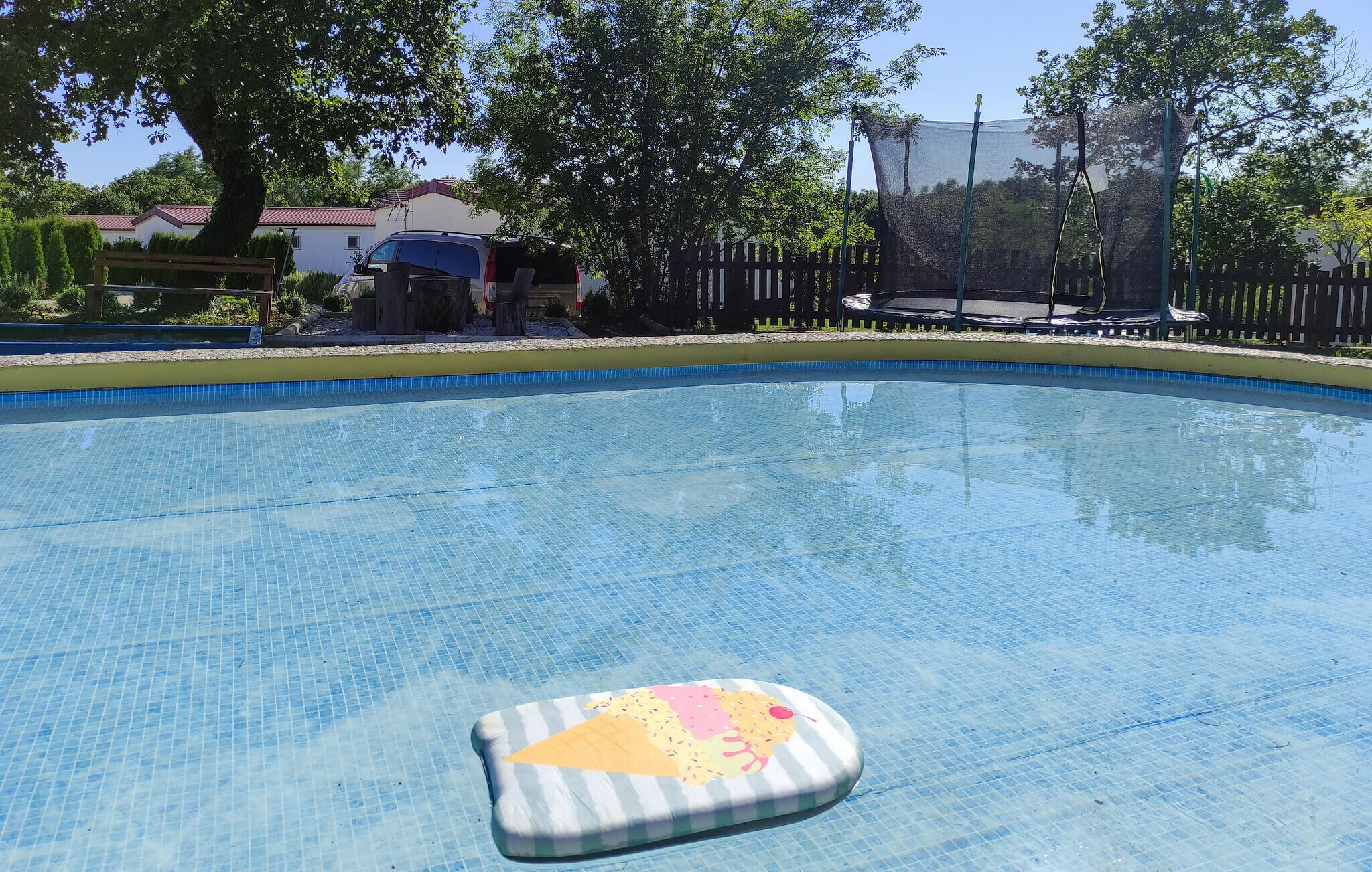 A clear swimming pool with a floating cushion in the center.