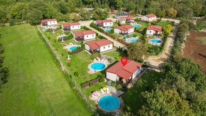An aerial view of a residential area with multiple houses, each featuring a swimming pool. - Amazing home in Tinjan (Tinjan)