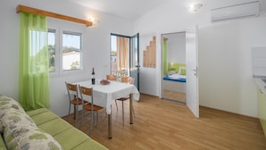 Una habitación moderna y bien iluminada con comedor, sofá y cama.