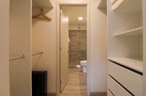 A narrow hallway with a radiator, a hanging coat rack, and a door leading to a bathroom with a toilet and shower. - w* | Ravishing 2BR w/ Balcony  in Miraflores (Miraflores)