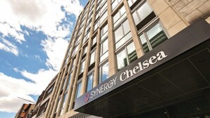 A building with a sign reading "SYNERGY Chelsea" and the number "232" on the facade.