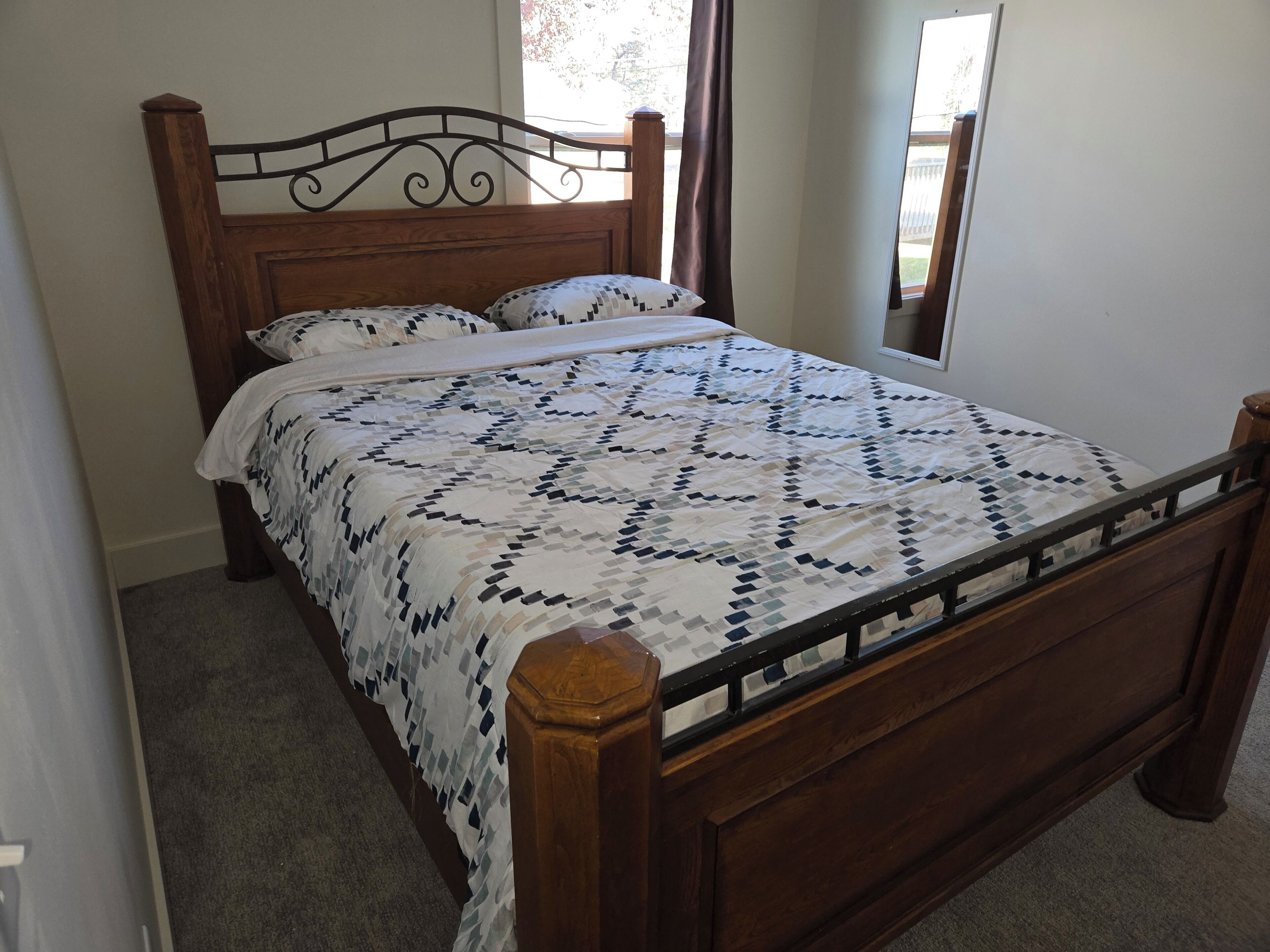A single bed with a wooden frame and a quilted bedspread.