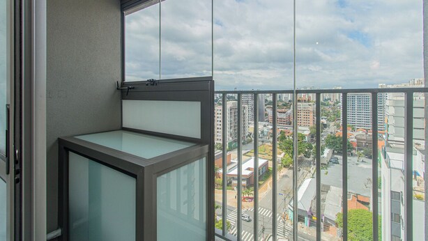 En balkon med udsigt over bybilledet, inklusive bygninger og en gade.