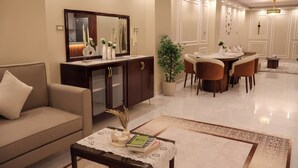 Una sala de estar moderna con sofá, mesa de centro y comedor con sillas y una mesa.