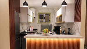 Una cocina moderna con una isla central, paneles de madera e iluminación colgante.