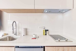 Een moderne keuken met een roestvrijstalen spoelbak, een inbouwfornuis en een houten plafond.