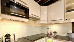 A modern kitchen with a built-in microwave, electric kettle, and induction cooktop. - Paris Loft for 4 by Châtelet & Montorgueil & Metro (PARIS)