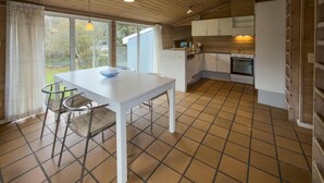 A compact kitchen with white cabinets, a white table, and a blue bowl. - Stunning home in Knebel (Knebel)