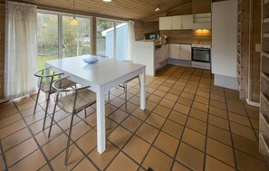 A compact kitchen with white cabinets, a white table, and a blue bowl. - Stunning home in Knebel (Knebel)