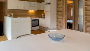 A compact kitchen with white cabinets, a stove, and a refrigerator. - Stunning home in Knebel (Knebel)