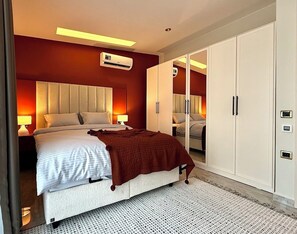 Ein modernes Schlafzimmer mit Bett, Nachttischlampen, einem Kleiderschrank und einer Klimaanlage.