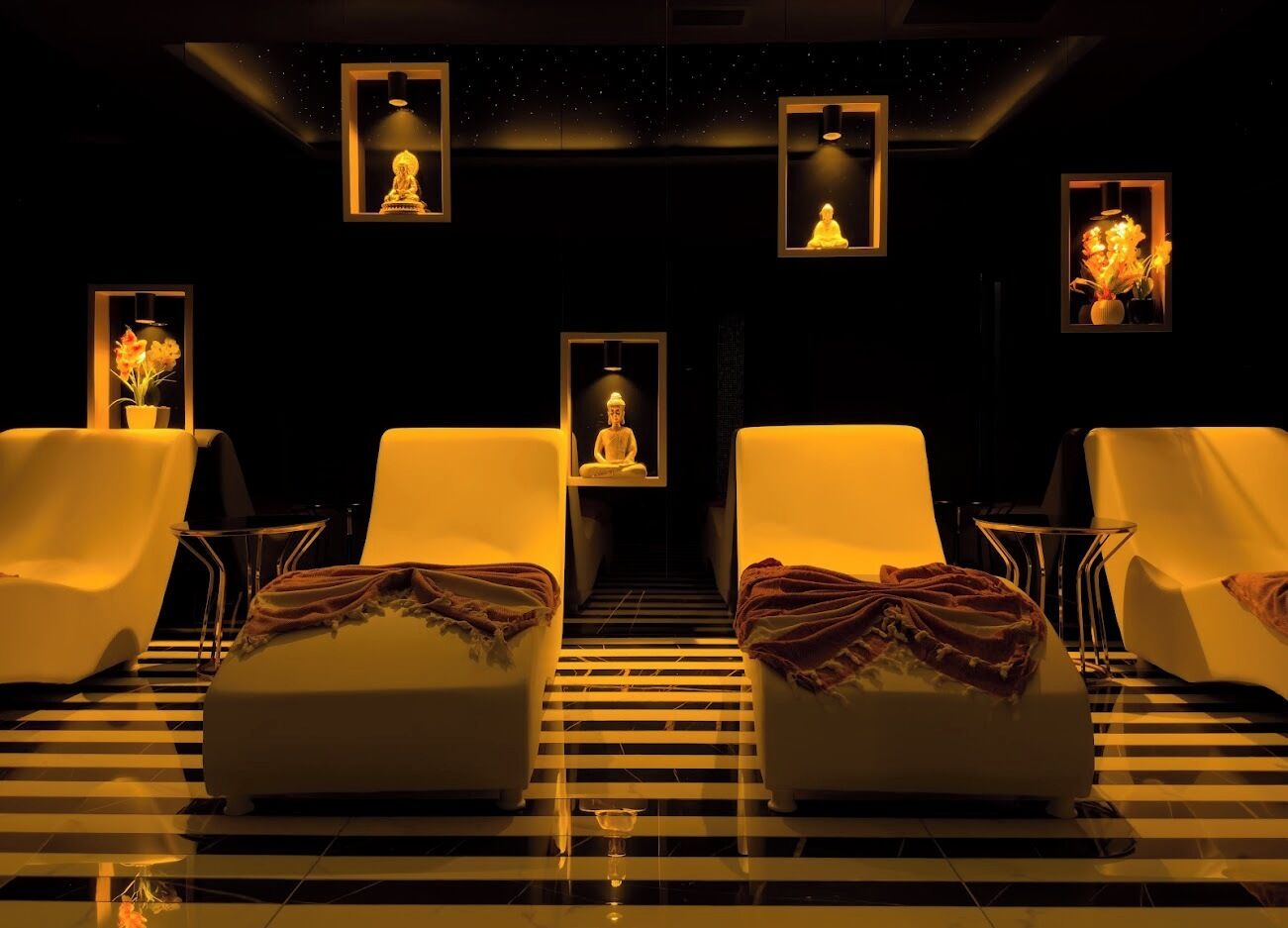 Ein Spa-Raum mit zwei Liegesesseln, einem kleinen Tisch und einer Bank.