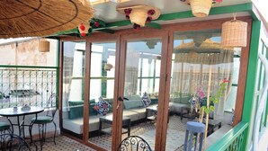 An outdoor patio with a dining table, chairs, and a sofa set. - Riad Dar Salma  (Fes)