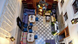 A courtyard with a seating area, a lantern, and a patterned floor. - Riad Dar Salma  (Fes)