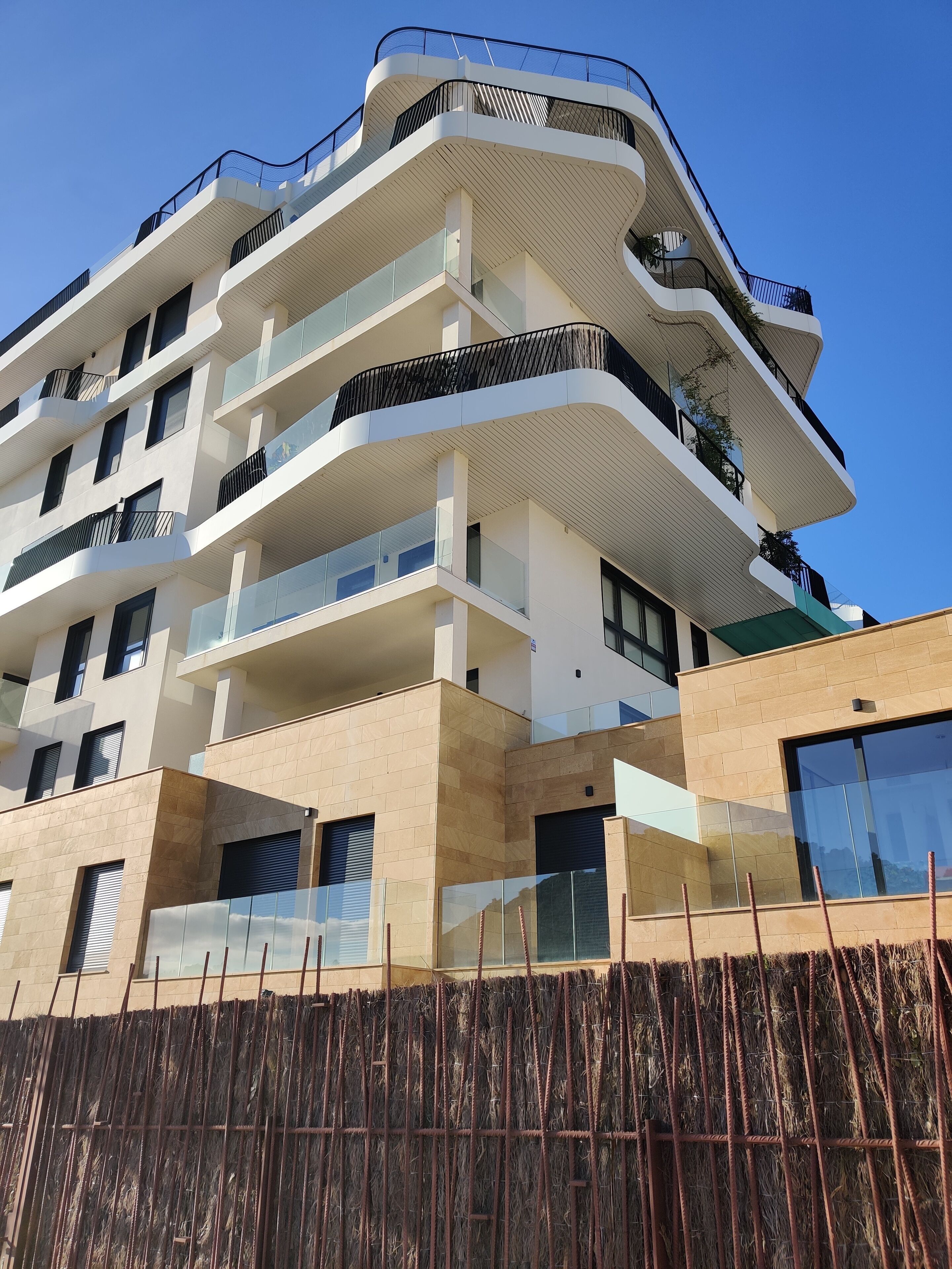 Un immeuble résidentiel à plusieurs étages, doté de balcons, de grandes fenêtres et d’une architecture moderne.