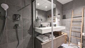 A modern bathroom with a glass-enclosed shower, a vanity with a mirror, and a wooden ladder. - Aster Apartments (Villajoyosa)