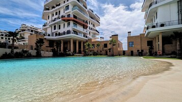 Una piscina cubierta, una piscina al aire libre de temporada, sombrillas