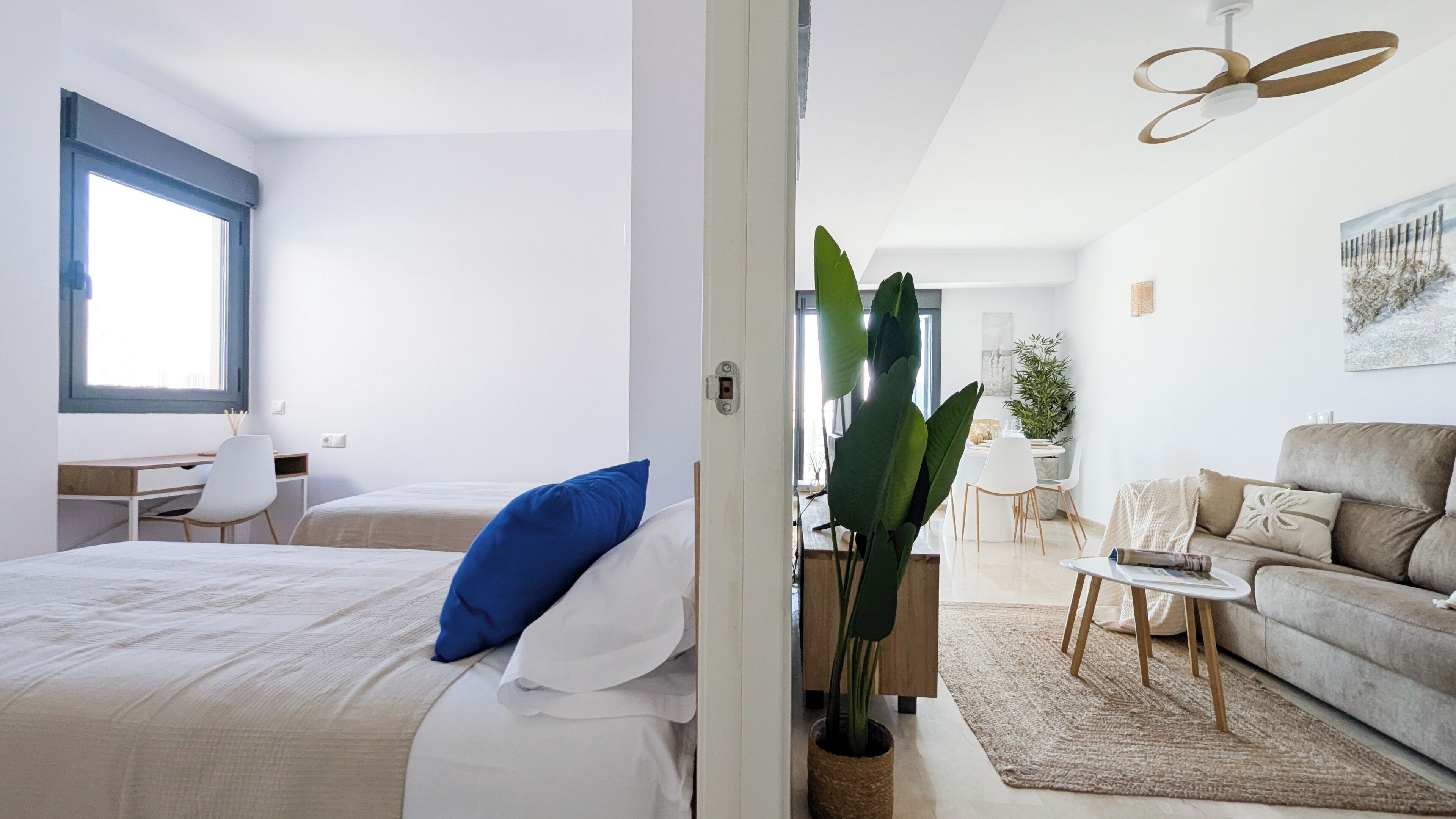Une chambre d’hôtel moderne comprenant un lit, un bureau, un coin repas et un espace de vie.