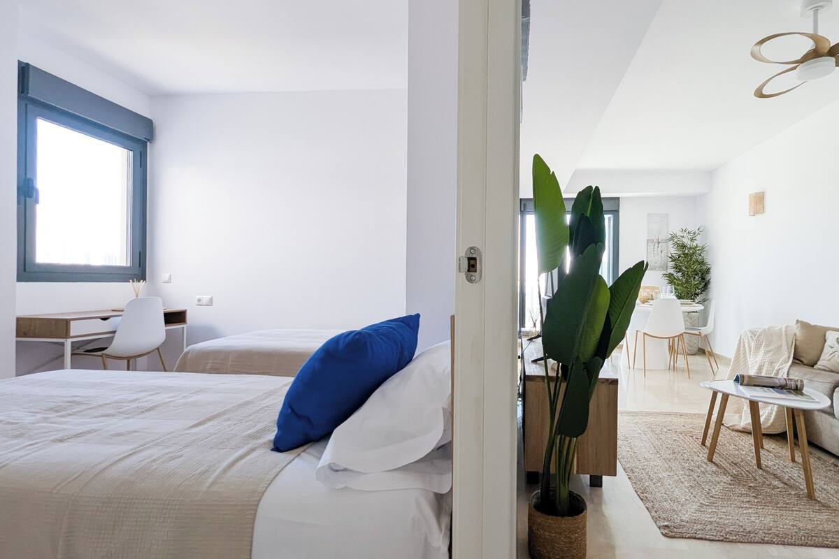 Une chambre d’hôtel moderne comprenant un lit, un bureau, un coin repas et un espace de vie.