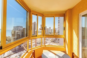 Une chambre d’angle avec de grandes fenêtres, une vue sur le paysage urbain et une petite table.