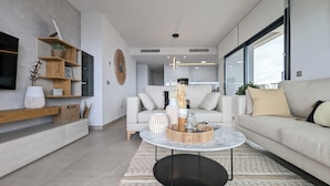 A modern living room with a sofa, coffee table, and shelves. - Sunset Cliffs Apartments Tower 2 (Benidorm)