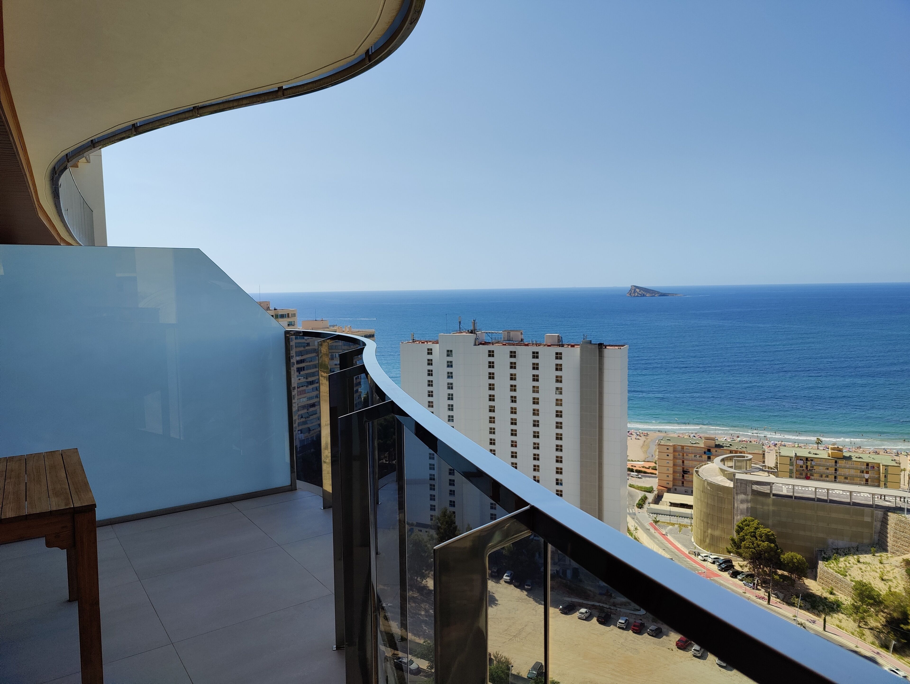 A balcony with a view of the sea and a beach.