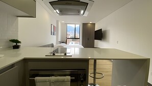 A modern kitchen with a central island, a built-in oven, and a view to the outside. - Edificio Loft 20-51 (Bogotá)