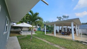 A covered outdoor area with a concrete floor, a hammock, and a table with chairs. - SOL Rooms (Túxpam de Rodríguez Cano)