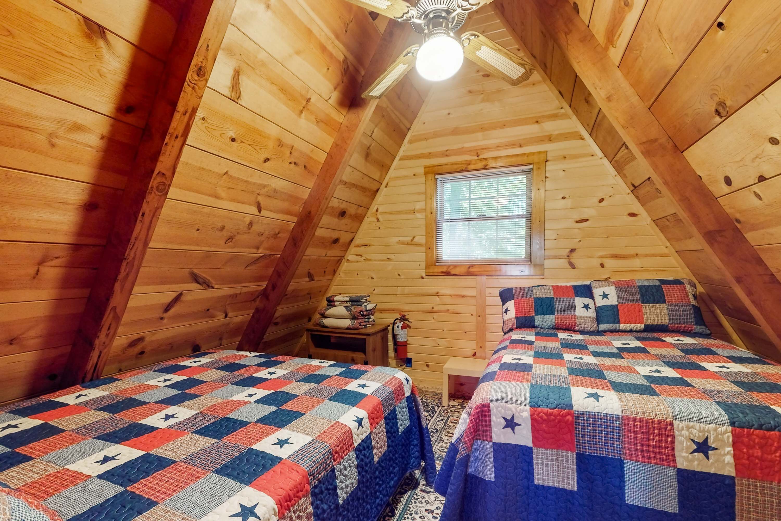 Une chambre mansardée chaleureuse, avec deux lits, un plafond en bois et une fenêtre.