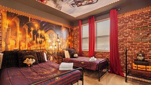 A room with two beds, a brick wall, and a mural of a castle. - Near Disney Villa: Private Pool & Game Room (Davenport)