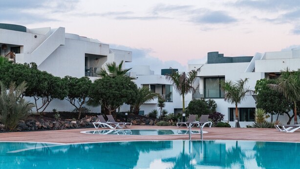 A modern resort with a swimming pool, lounge chairs, and a landscaped garden. - Serenidad del Sol Fuerteventura (Villaverde)