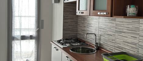 Een koelkast, een oven, een kookplaat, een koffiezetapparaat/waterkoker