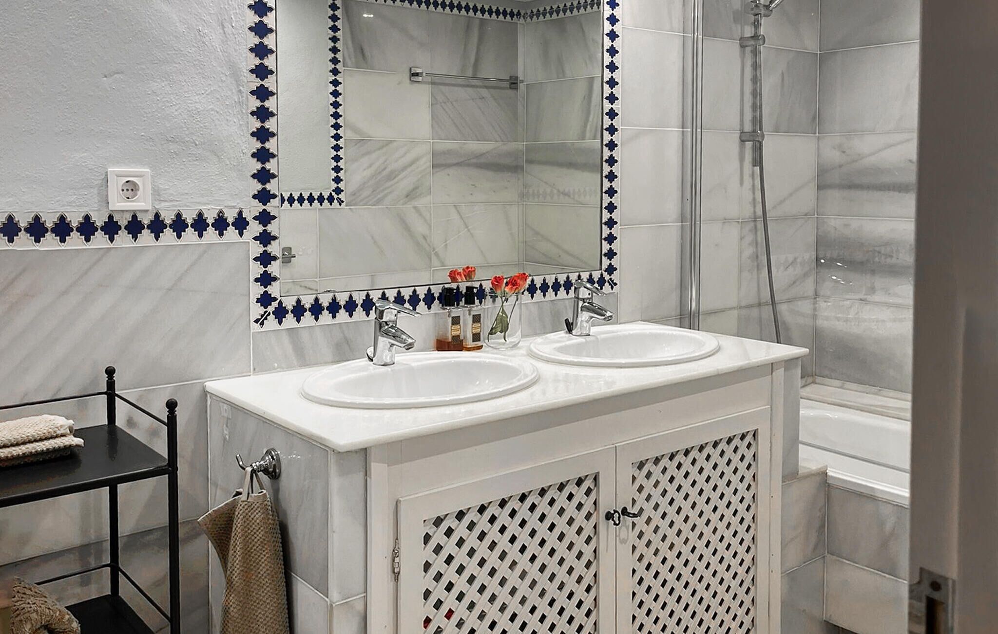 A bathroom with two sinks, a mirror, and a shower.