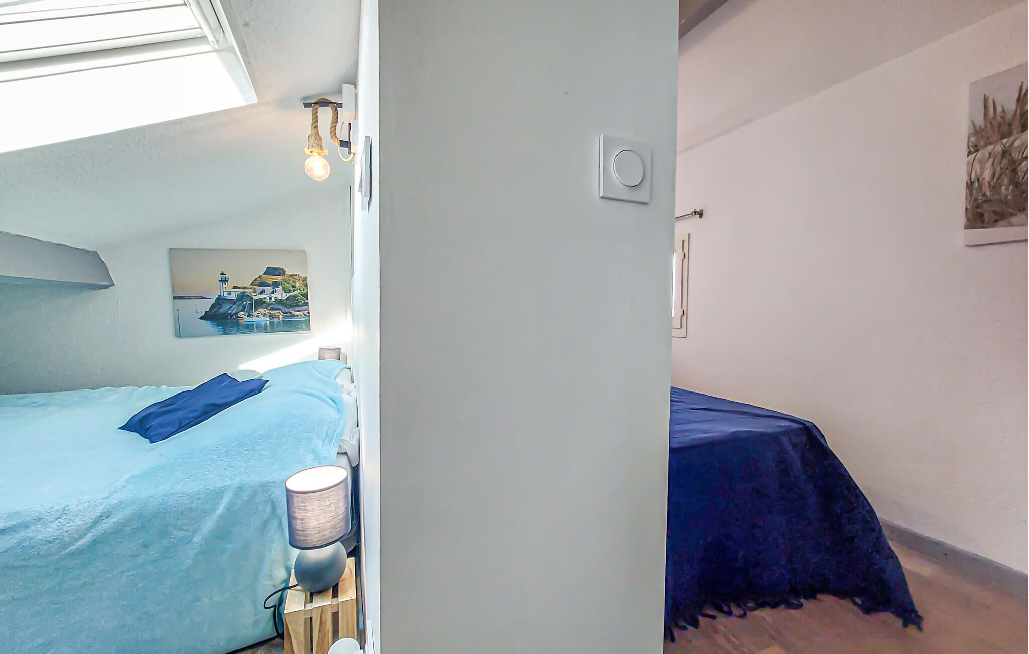 Une chambre à coucher avec un lit, une table de chevet, une lampe et un tableau au mur.