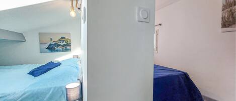 Une chambre à coucher avec un lit, une table de chevet, une lampe et un tableau au mur.