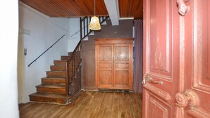 A wooden staircase with a handrail, a wooden door with a decorative handle, and a hanging light fixture. - 3 bedroom gorgeous apartment in OLMETO (OLMETO)