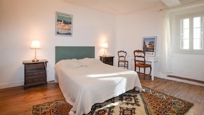 A bedroom with a bed, two bedside tables with lamps, a chair, a poster on the wall, and a window with curtains. - 3 bedroom gorgeous apartment in OLMETO (OLMETO)