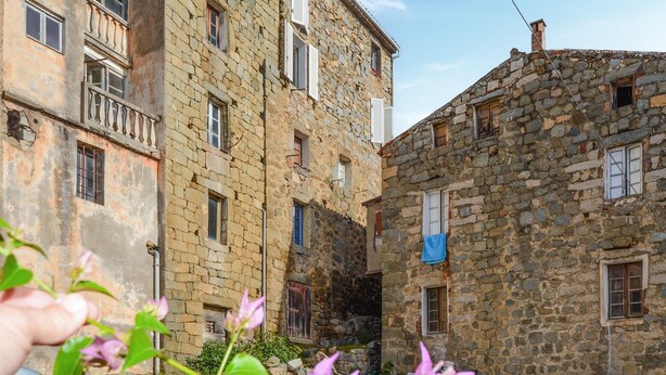 A narrow street with stone buildings, some with balconies and windows, and a small garden area with flowers. - 3 bedroom gorgeous apartment in OLMETO (OLMETO)